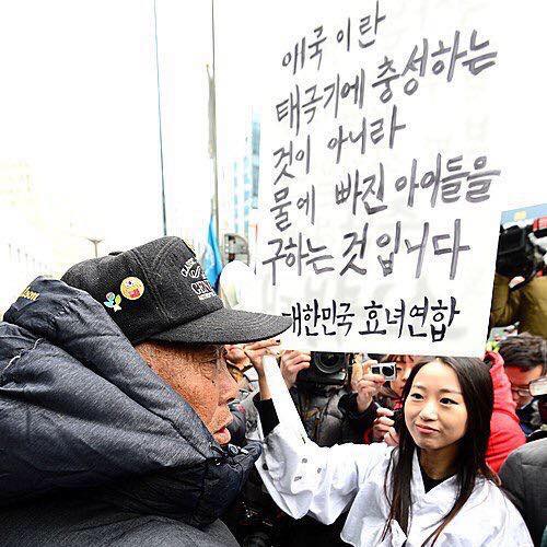 효녀연합의 홍승희씨가 지난 1월 서울 일본대사관 앞 위안부 소녀상에서 어버이연합의 한 회원 앞에서 플래카드를 들고 1인 시위를 하고 있다. 효녀연합 페이스북