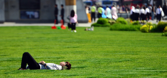 24일 서울 광화문 광장에서 한 시민이 잔디밭에 누워 휴식을 취하고 있다. 2016. 4. 24. 박윤슬 기자 seul@seoul.co.kr