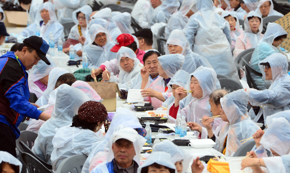 비가 내린 6일 오후 서울 용산가족공원에서 열린 어버이날 기념식에서 어르신들이 도시락을 먹고 있다.  박윤슬 기자 seul@seoul.co.kr