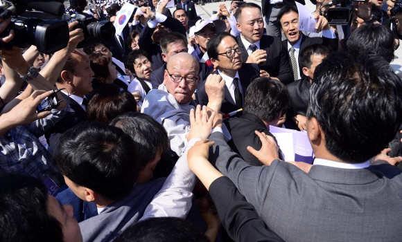 국가보훈처가 5·18민주화운동 36주년 기념식을 18일 오전 광주시 북구 국립5·18민주묘지에서 거행하는 가운데 박승춘 국가보훈처장이 5·18민주유공자유족회원들로부터 거센 항의를 받고 있다. 이번 기념식에 5·18민주유공자유족회를 비롯한 5월 3단체 회원과 정부 측 대표자인 황교안 국무총리, 행사를 주관하는 박승춘 국가보훈처장, 여·야 국회의원 등 정치권 인사, 시민 등 3000여명이 참석했다. 박근혜 대통령은 올해도 참석하지 않았다.  손형준 기자 boltagoo@seoul.co.kr