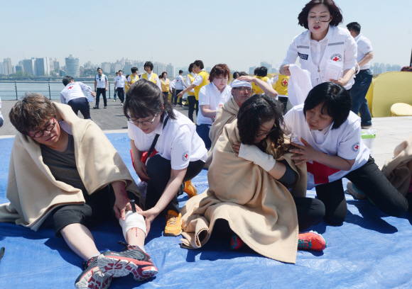 18일 오전 서울 여의도에서 국민안전처·대한적십자사 주최로 열린 수도권 복합재난 대비 민·관·군 합동 대응훈련에서 의료진이 응급처치를 하고 있다. 안주영 기자 jya@seoul.co.kr