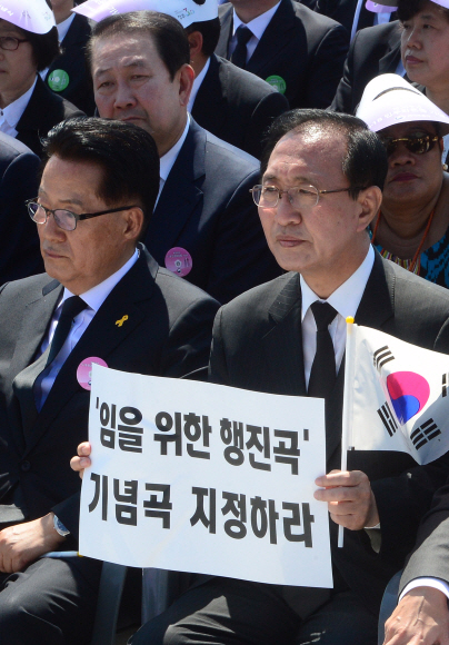18일 광주 국립5·18 민주묘역에서 열린 기념식에서 노회찬 정의당 의원이 임을 위한 행진곡 기념곡 지정하라 문구가 적힌 손푯말을 들고 있다.  손형준 기자 boltagoo@seoul.co.kr