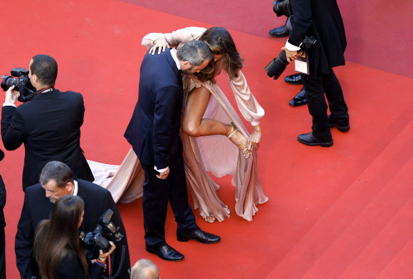 모델 이자벨 굴라르가 17일(현지시간) 프랑스 칸에서 열린 ‘제69회 칸 국제영화제’ 에서 영화 ‘줄리에타(Julieta)’ 레드카펫에서 드레스가 신발에 걸려 빼내고 있다. EPA 연합뉴스