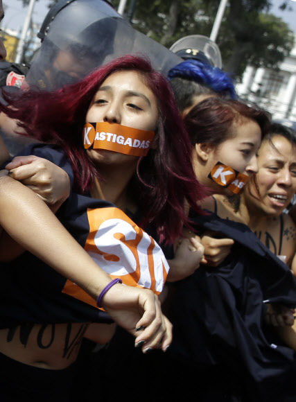 지난달 치러진 페루 대선에서 1위를 차지한 게이코 후지모리 민중권력당(FPP) 후보에 반대하는 여성들이 19일(현지시간) 수도 리마의 의사당 앞에서 ’게이코(KEIKO)’라는 글씨를 써놓은 가슴을 드러내놓고 시위를 벌이다 진압경찰과 충돌하고 있다.AP 연합뉴스