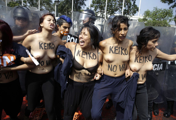 지난달 치러진 페루 대선에서 1위를 차지한 게이코 후지모리 민중권력당(FPP) 후보에 반대하는 여성들이 19일(현지시간) 수도 리마의 의사당 앞에서 ’게이코(KEIKO)’라는 글씨를 써놓은 가슴을 드러내놓고 시위를 벌이다 진압경찰과 충돌하고 있다.AP 연합뉴스
