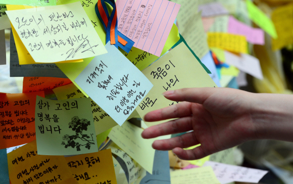 20일 서울 강남역 10번 출구 앞에서 시민들이 ’강남 묻지마 살인사건’의 20대 여성 희생자 추모 메시지를 적은 포스트잇을 붙이고 있다. 박윤슬 기자 seul@seoul.co.kr