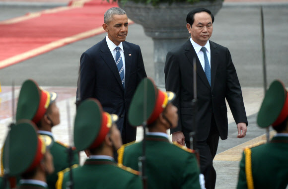 버락 오바마 미국 대통령(왼쪽)이 23일(현지시간) 베트남 하노이 주석궁에서 열린 공식 환영행사 참석을 위해 쩐 다이 꽝 베트남 국가 주석과 나란히 입장하고 있다. AFP 연합뉴스