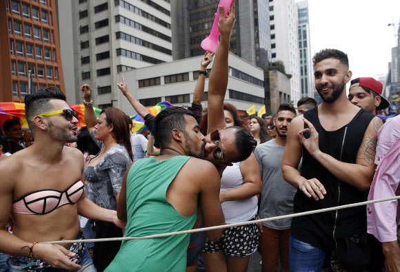 29일(현지시간) 브라질 상파울루에서 열린 세계 최대규모의 동성애자 축제 ‘파라다 게이(Parada Gay)’ 참가자들이 행진중 키스를 하고 있다. AP 연합뉴스