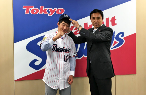 외야수 하재훈이 30일 일본 도쿄 야쿠르트 스왈로스 구단 사무실에서 열린 입단 기자회견에서 구단 관계자로부터 모자를 받고 있다.  스포츠인텔리전스그룹 제공