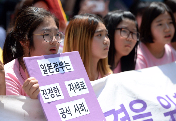 1일 서울 종로구 구일본대사관 앞에서 열린 ’일본군 위안부 문제 해결을 위한 제1233차 정기 수요집회’에 참가한 학생들이 정부와 일본을 규탄하는 팻말을 손에 들고 있다.2016. 6. 1. 박윤슬 기자 seul@seoul.co.kr