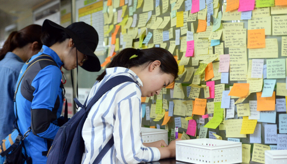 1일 서울 광진구 2호선 구의역 역무실 옆에 마련된 스크린도어 수리공 사망 사고 추모공간에서 시민들이  희생자를 추모하는 포스트잇 메시지를 적고 있다. 2016. 6. 1. 박윤슬 기자 seul@seoul.co.kr