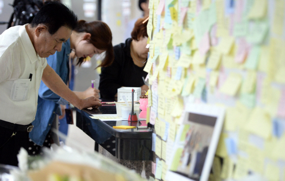 1일 서울 광진구 2호선 구의역 역무실 옆에 마련된 스크린도어 수리공 사망 사고 추모공간에서 시민들이  희생자를 추모하는 포스트잇 메시지를 적고 있다. 2016. 6. 1. 박윤슬 기자 seul@seoul.co.kr