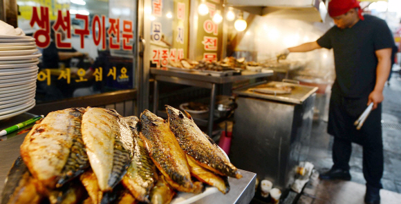 1일 서울 종로구 동대문 생선구이 골목에 있는 한 식당에서 상인이 하얀 연기를 내뿜으며 생선을 굽고 있다. 박윤슬 기자 seul@seoul.co.kr