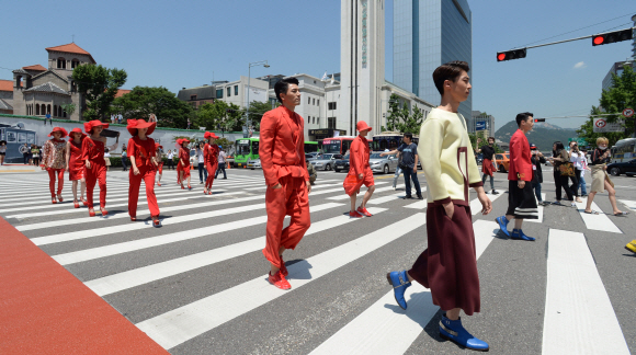 2일 서울 중구 세종대로 서울시청 신청사와 시의회 건물 사이에 신설된 횡단보도에서 열린 횡단보도 패션쇼에 참가한 모델들이 3색 신호등을 모티브로 제작된 의상을 입고 횡단보도를 건너고 있다. 이번 행사는 공원, 광장, 보행전용거리, 청계천 등 서울의 명소를 패션쇼 무대로 삼아 일상 속에서 시민 누구나 패션쇼를 즐길 수 있도록 서울시가 마련한 서울 365패션쇼의 일환으로 열렸다. 손형준 기자 boltagoo@seoul.co.kr