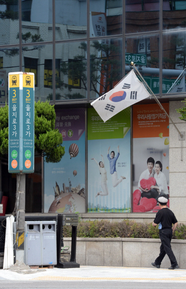 현충일인 6일 서울 중구의 한 은행 앞에 태극기가 펄럭이고 있다. 현충일은 나라를 위해 목숨을 바친 국군 장병과 순국선열의 충성을 기리는 날로, 이날 태극기를 걸 때는 태극기 세로면 길이만큼 내려 거는 ‘조기 게양’을 해야 한다.  박윤슬 기자 seul@seoul.co.kr