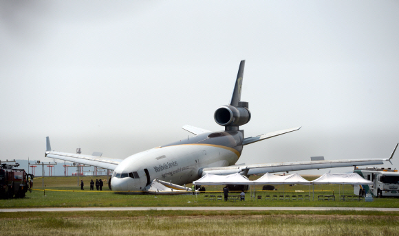 6일 오후 10시50분께 인천국제공항 1활주로에서 이륙 중 랜딩기어 고장으로 이륙하지 못하고 비상 착륙한 미국 국적의 UPS화물기 주변에 7일 오전 사고 수습을 위해 공항관계자와 소방당국이 작업을 하고 있다.  강성남 선임기자 snk@seoul.co.kr