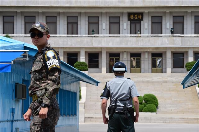 JSA 경비대대 병사가 기마 자세를 취하고 북한의 ‘판문각’ 쪽을 바라보고 있는 가운데 선글라스를 쓴 우리 측 병사(왼쪽)가 견학 인원을 인솔하고 있다. 한미연합사 제공