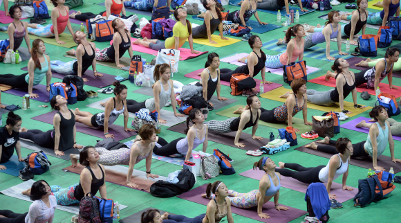 12일 서울 장충제육관에서 열린 요가 마라톤에 참가한 요가동호인들이 강사의 지도에 맞춰 요가동작을 하고 있다.  박지환 기자 popocar@seoul.co.kr