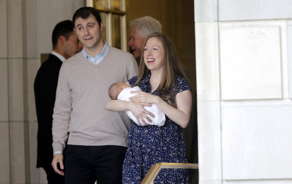 첼시 클린턴이 20일(현지시간) 새로 태어난 그녀의 아들 에이단을 안고 남편 마크 메즈빈스키와 함께 뉴욕의 병원을 나서고 있다. EPA 연합뉴스