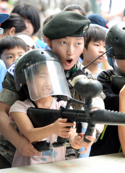 21일 오전 서초구청 광장에서 열린 ’호국보훈의 달 안보 전시회’에 견학 온 어린이들이 군인들의 도움을 받으며 군훈련용 실제 총기류에 서바이벌 실탄(물풍선) 사격을 해 보고 있다. 2016.06.21 강성남 선임기자 snk@seoul.co.kr