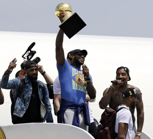 클리블랜드의 미국프로농구(NBA) 제패를 이끈 르브론 제임스(가운데)가 20일(현지시간) 클리블랜드 공항에 도착한 뒤 챔피언 트로피를 들어 보이며 기쁨을 만끽하고 있다.   클리블랜드 AP 연합뉴스 