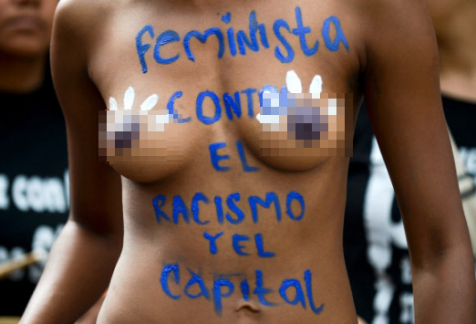 26일(현지시간) 콜롬비아 칼리에서 열린 게이 프라이드 퍼레이드에서 한 페미니스트가 벌거벗은 몸에 “페미니스트는 인종차별과 사형제도에 반대한다” 쓴채 거리를 행진하고 있다. AFP 연합뉴스