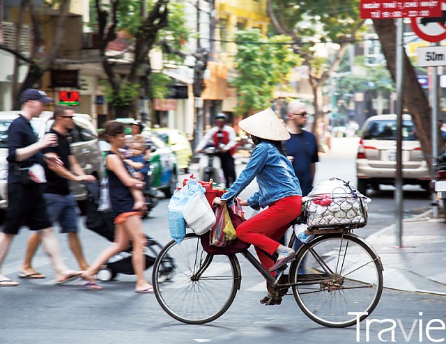 자전거에 물건을 잔뜩 싣고 여행자 사이를 누비는 베트남 여인