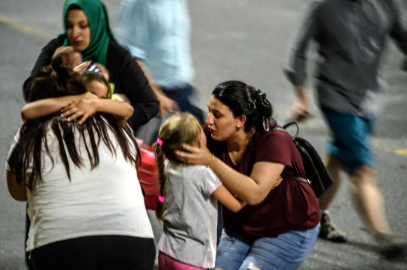 28일(현지시간) 밤 터키 최대도시 이스탄불의 아타튀르크 국제공항에서 자살폭탄 테러가 발생한 후 아이들과 친척들이 공항을 떠나면서 서로 포옹하고 있다.AFP 연합뉴스