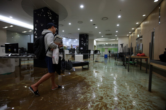 1일 오후 장맛비에 침수된 서울 연세대학교 중앙도서관 내 물이 새어나온 부분에 유리파편들이 흩어져 있다. 연합뉴스