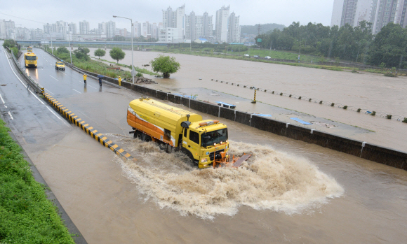 서울, 경기 등 중부지방에 호우경보가 내려진 5일 서울 중랑천 중랑교 아래에서 침수된 동부간선도로에 쌓인 진흘과 강물을 중장비를 이용해 밀어내고 있다. 손형준 기자 boltagoo@seoul.co.kr