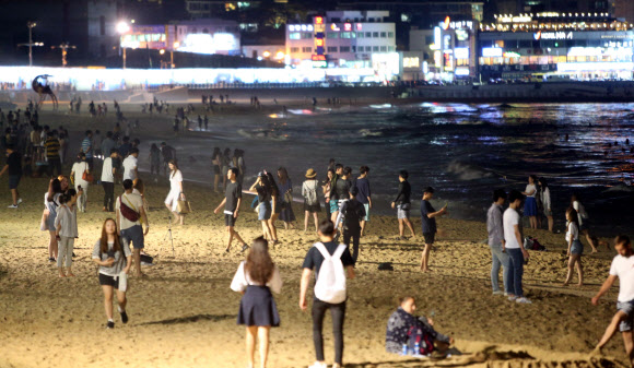 부산 해운대해수욕장을 찾은 나들이객들이 시원한 여름밤 정취를 만끽하고 있다.  연합뉴스