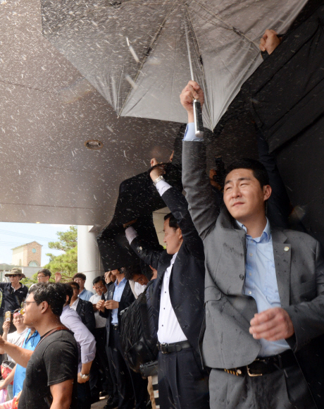 15일 오전 경북 성주군청을 방문한 황교안 국무총리와 한민구 국방부장관의 머리 위로 군민들이 던진 달걀이 지나가자 경호원들이 우산으로 막고 있다. 2016.7.15 도준석 기자 pado@seoul.co.kr