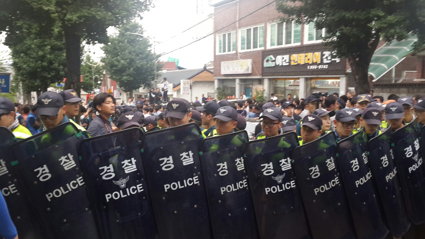 경찰들이 방패를 들고 황교안 국무총리가 탄 차를 보호하고 있다.