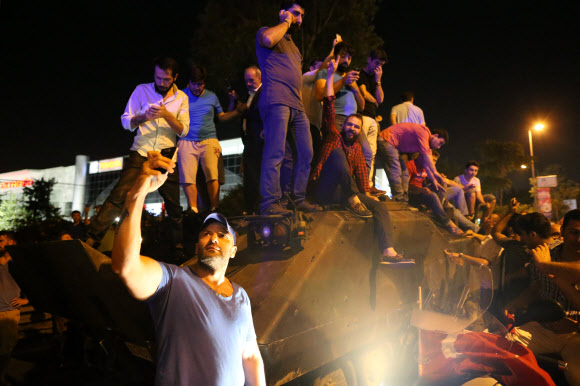 16일(현지시간) 터키에서 군부 쿠데타가 일어난 가운데 이스탄불 시민들이 탱크를 점거하고 있다. 비날드리 이을드름 터키 총리는 군부 쿠데타 시도가 있었다고 발표한 반면 군부는 국영방송을 통해 자신들이 권력을 통제하고 있다고 밝혔다. AP 연합뉴스