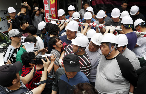 18일 오전 서울 신사동 가로수길에 있는 곱창집 ’우장창창’의 2차 강제집행 도중 대표 서윤수씨, 맘편히장사하고픈상인모임 회원들과 철거 용역업체 직원들이 충돌하고 있다. 연합뉴스