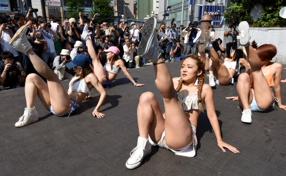 18일(현지시간) 일본 도쿄의 신주쿠역 앞 광장에서 비키니를 입은 여성들이 춤을 추며 플래시몹 이벤트를 하고 있다. AFP 연합뉴스