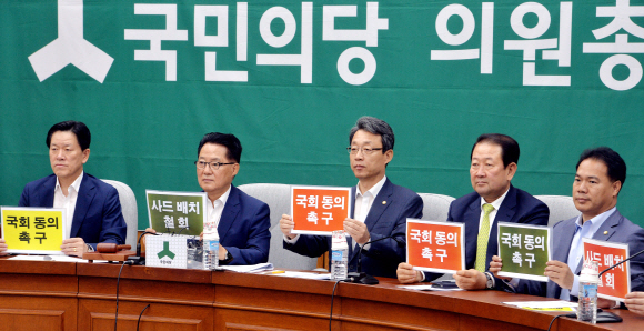 국민의당 의원들이 19일 국회에서 열린 의원총회에서 사드배치와 관련해 국회동의를 촉구하며 피켓을 들어 보이고 있다.   이종원 선임기자 jongwon@seoul.co.kr