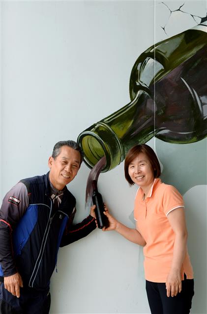양재영, 국중순씨 부부가 와인 이미지를 배경으로 한 포토존에서 와인병을 함께 들고 활짝 웃고 있다.  정읍 강성남 선임기자 snk@seoul.co.kr