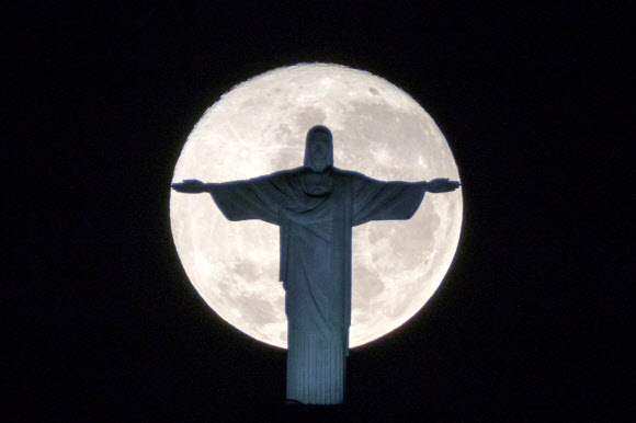 19일(현지시간) 브라질 리우데자네이루의 코르코바도산에 위치한 리우데자네이루의 명물 ‘예수상(Christ the Redeemer)’ 뒤로 보름달이 떠 있다. AFP 연합뉴스