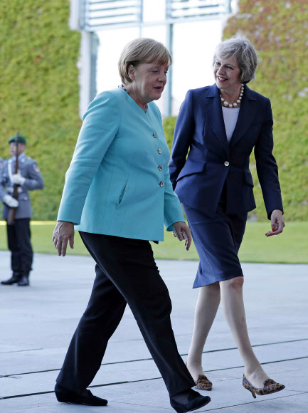 20일(현지시간) 테리사 메이 영국 총리(오른쪽)와 앙겔라 메르켈 독일 총리가 의장대 사열을 하며 대화를 나누고 있다. AP 연합뉴스