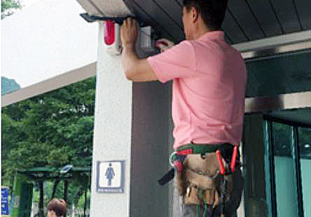 군포시 관계자가 공중화장실에 비상벨을 설치하고 있다.<br>군포시 제공<br>