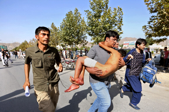 지난 23일 수니파 무장단체 이슬람국가(IS)의 자폭테러로 80명이 사망하자 아프가니스탄 정부가 27일 IS근거지를 습격, 대원 122명을 사살했다. 사진은 당일 아프간 시민들이 이번 테러로 다친 소년을 안고 병원으로 달려가는 모습. 사진=AP 연합뉴스