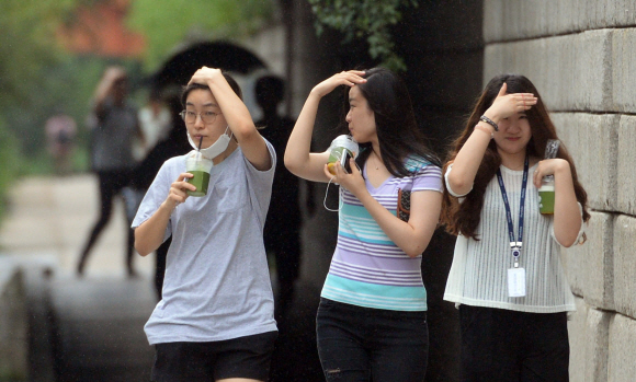 갑작스런 비가 내린 27일 서울 청계천일대에서 우산을 미처 준비하지 못한 시민들이 손으로 비를 피하고 있다. 2016.7.27 박지환기자 popocar@seoul.co.kr
