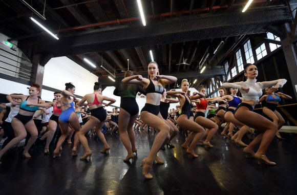 28일(현지시간) 호주 시드니에서 프랑스 유명 공연단 ‘물랑루즈’의 댄서를 모집하는 오디션이 열려 댄서들이 춤을 추고 있다.  물랑루즈는 1889년 프랑스 몽마르트르에서 문을 열었다. 프랑스어로 ‘붉은 풍차(Moulin Rouge)’라는 뜻으로 건물 옥상의 크고 붉은 네온사인 풍차 때문에 붙여진 이름이다. 영화로도 여러 차례 제작됐을 정도로 유명하다. AFP 연합뉴스