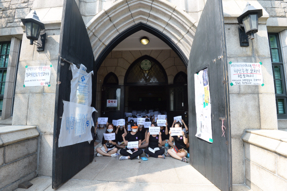 31일 서울 서대문구 이화여자대학교 본관 출입구에서 이화여대학생들이 피켓을 들고 농성을 하고 있다. 이화여대 학생들은 교육부의 ’평생교육 단과대학 지원사업’의 일환으로 추진되고 있는 ’미래라이프대학’ 설립에 반발, 김활란 동상에 페인트를 칠하고 계란을 던지는 등 28일부터 본관건물에서 농성을 이어가고 있다.  박윤슬 기자 seul@seoul.co.kr