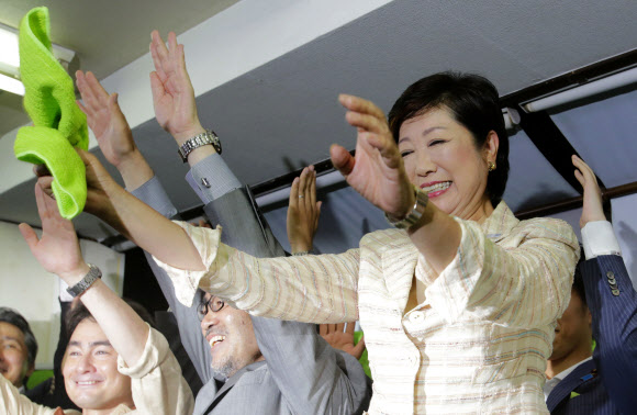 고이케 유리코(오른쪽) 일본 도쿄도지사 후보가 31일 출구조사 결과 당선이 확실시되자 도쿄시의 선거사무소에서 지지자들의 환호에 손을 들어 답하고 있다. 도쿄 AP 연합뉴스
