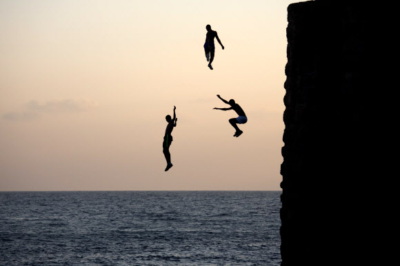 이스라엘 소년들이 2일(현지시간) 이스라엘 북부 아크레시의 지중해 인근에 위치한 절벽에서 바다를 향해 뛰어들고 있다. AP 연합뉴스