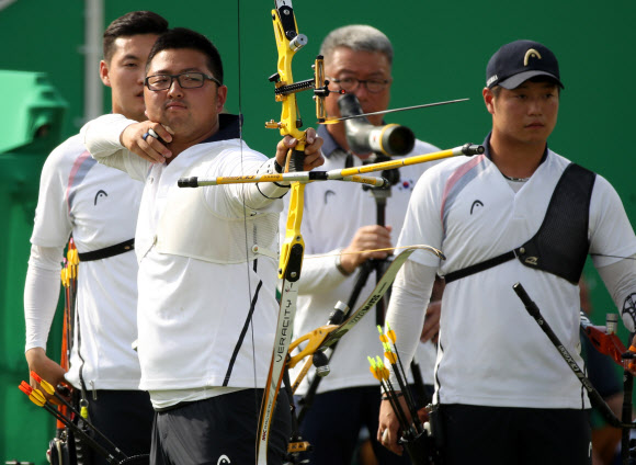 한국 선수단 첫 금메달을 안긴 남자양궁 대표팀이 7일 오전 브라질 리우데자네이루 삼보드로모 경기장에서 열린 2016 리우올림픽 단체전 네덜란드와의 8강전 도중 김우진이 활시위를 당기고 있다. 바로 뒤가 구본찬, 오른쪽이 이승윤. 리우데자네이루 연합뉴스