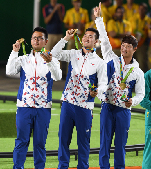 남자양궁 구본찬 김우진 이승윤이 6일 오후(현지시간)브라질 리우데자네이루 마라카낭 삼보드로무 경기장에서 열린 2016 리우 올림픽 양궁 남자 단체전 결승에서 미국을 꺾고 금메달을 획득했다. 시상식에서 금메달을 목에 걸고 기뻐하는 세 선수의 모습. 리우데자네이루=올림픽사진공동취재단