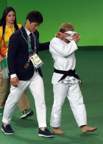 정보경 선수가 5일 오전(현지시간) 브라질 리우데자네이루 바하 올림픽파크 경기장에서 열린 유도 여자 48kg급 이하 결승전에서 아르헨티나 파울라파레토 선수에게 패해 은메달을 차지했다. 정 선수가 경기가 끝난뒤 이원희 코치의 위로를 받으며 퇴장하고 있다. 리우데자네이루=올림픽사진공동취재단